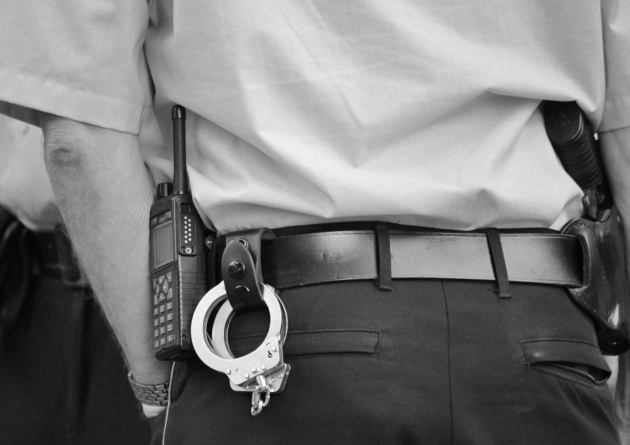 Policier de dos avec des menottes